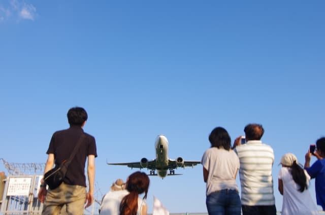 離陸する飛行機を下から見る人々